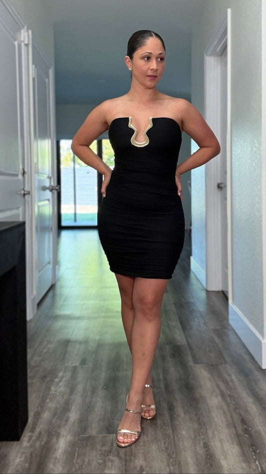 Strapless black mini dress with ruching and gold u-shaped accent