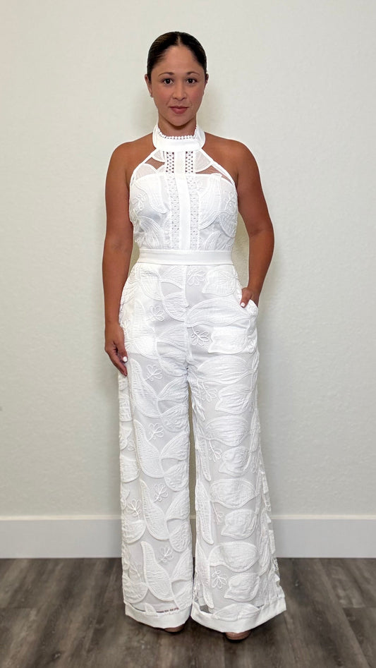 Woman wearing a white lace jumpsuit with fitted bodice and wide leg trousers