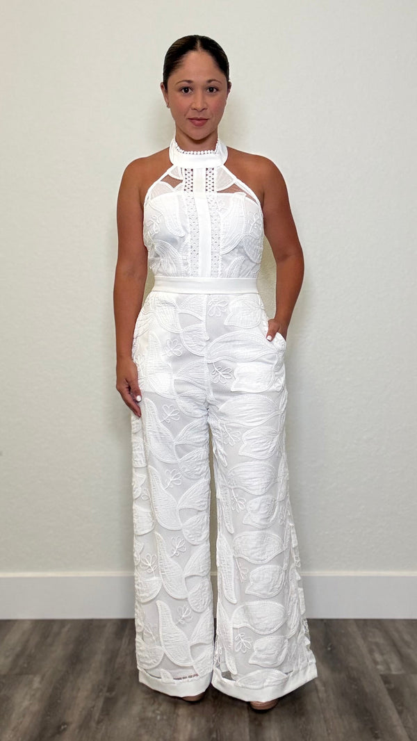 Woman wearing a white lace jumpsuit with fitted bodice and wide leg trousers