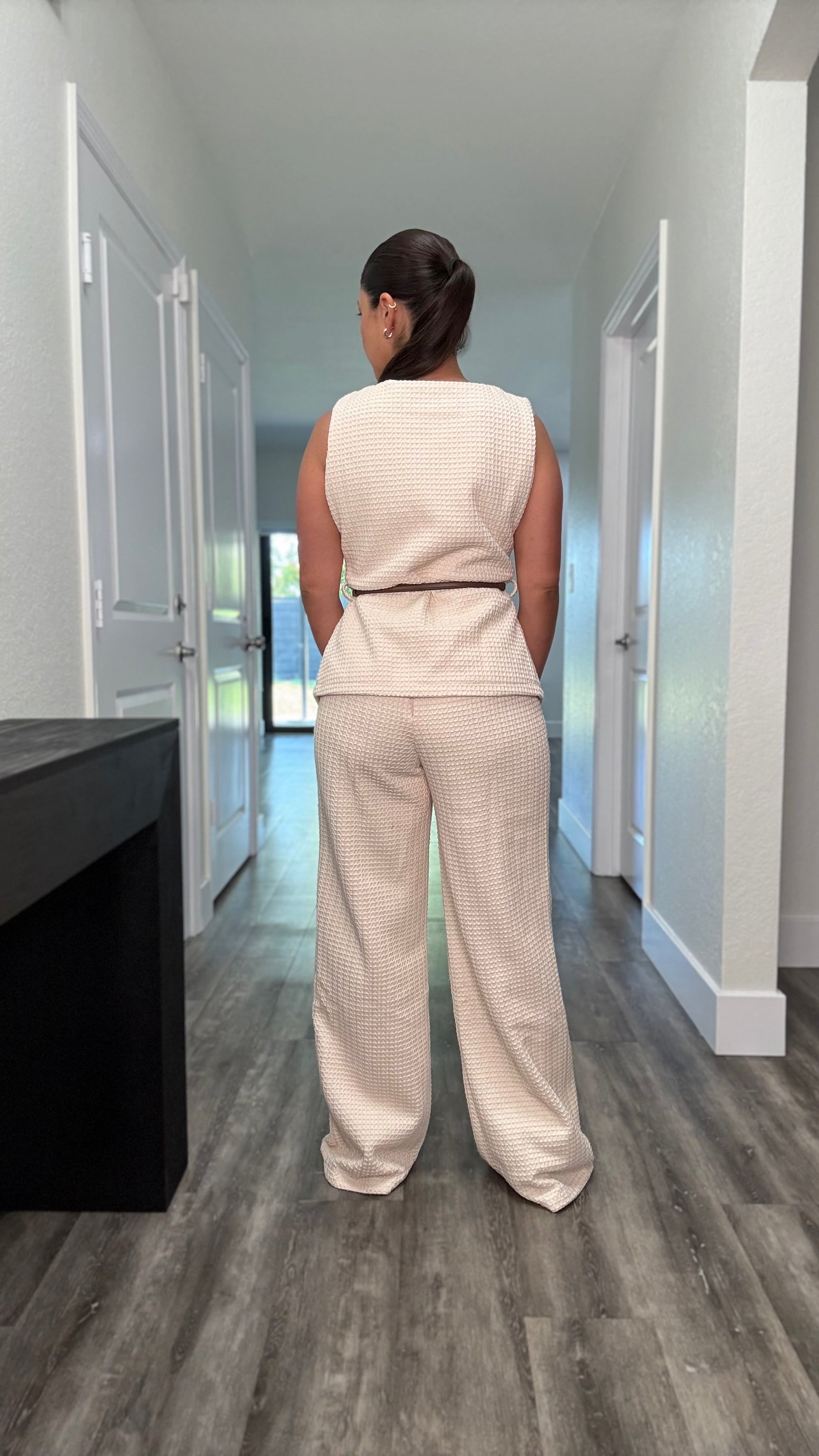 back of taupe textured pants set with brown belt around the waist